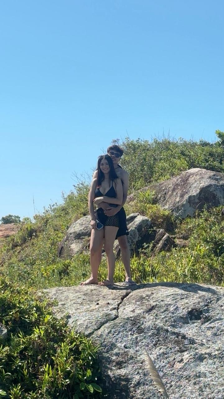 Jean e Nycole abraçados durante um passeio em um lugar cheio de pedras e natureza