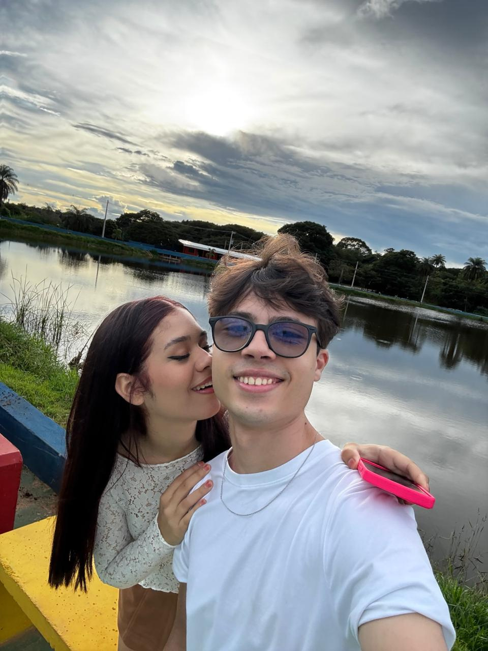 Jean e Nycole sorrindo durante um passeio à beira de um lago